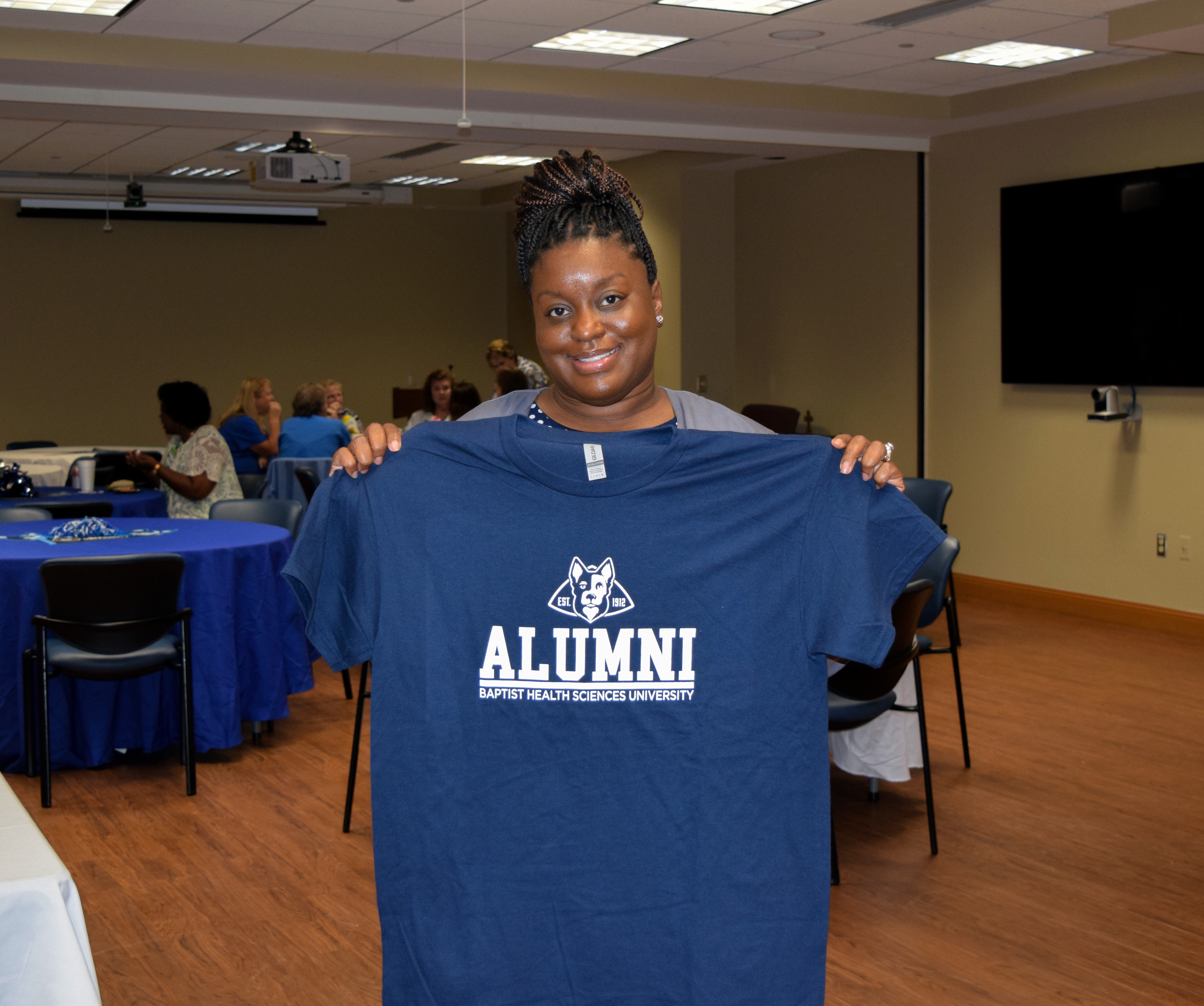 Alumni holding shirt 