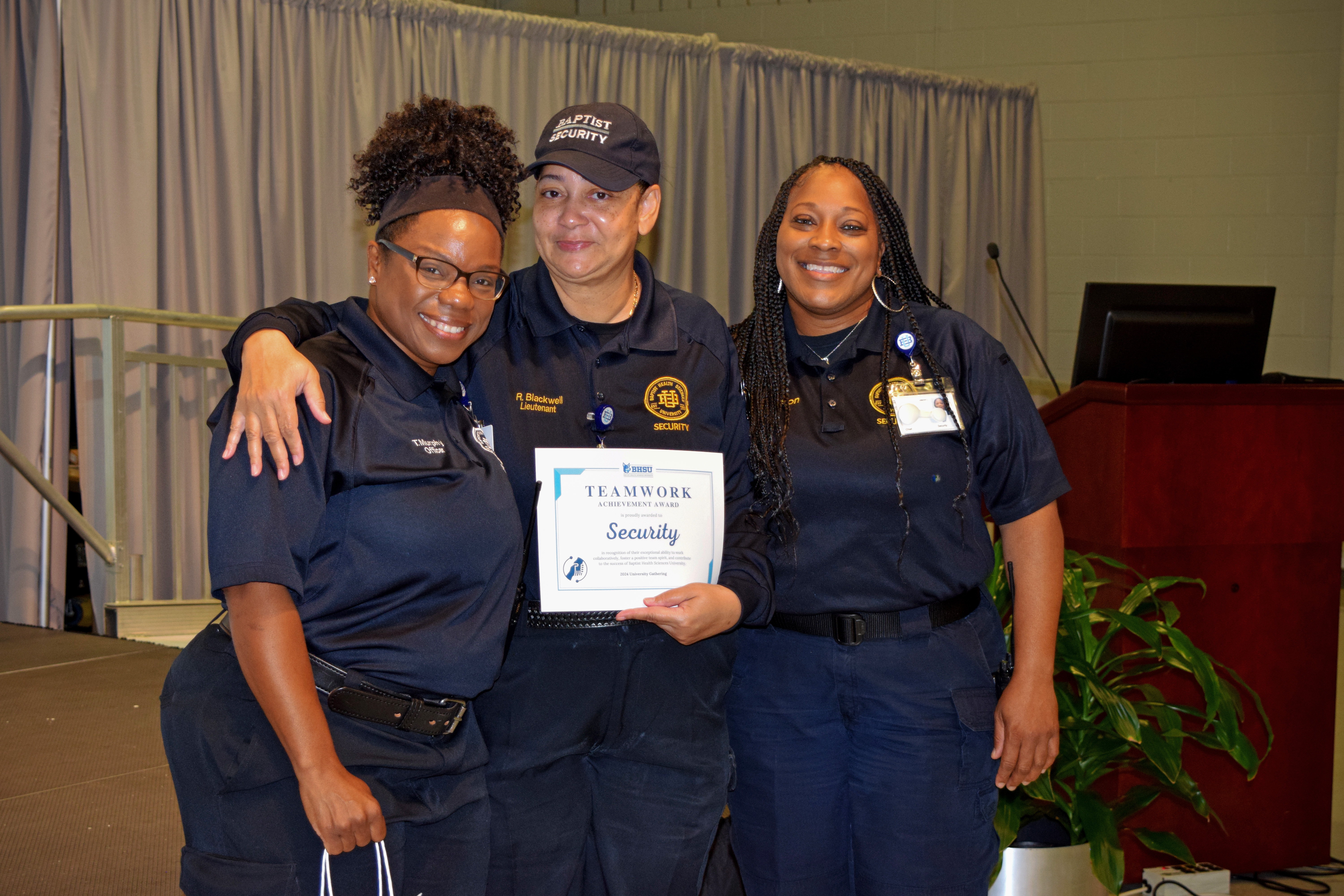 Three security officers with the teamwork award