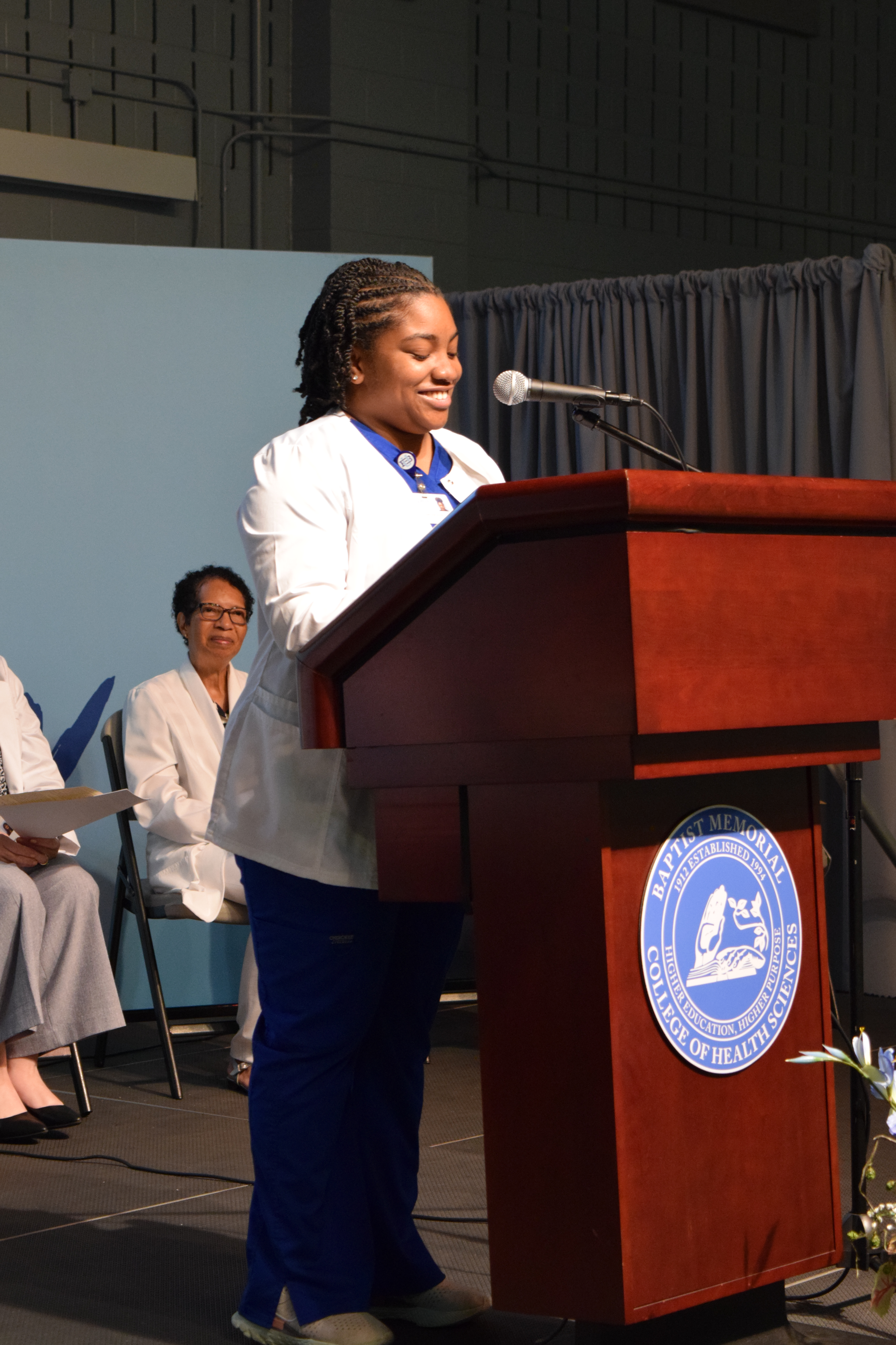 Nursing student looking at the camera smiling at white coat ceremony