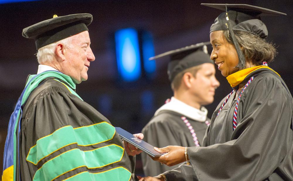 Dr. Cochran presenting diploma to an April 2017 grad