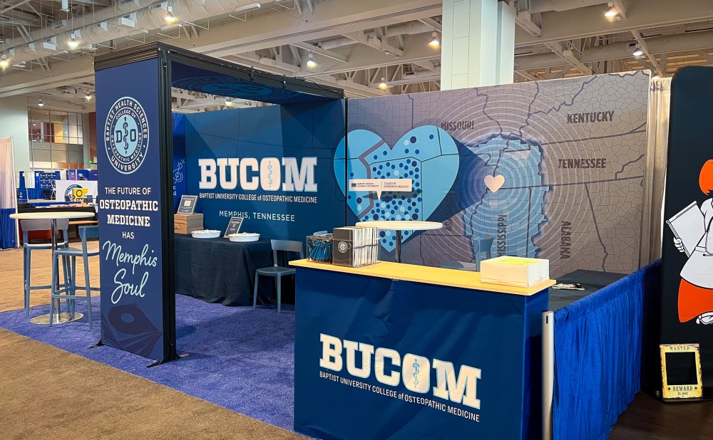 BUCOM exhibit booth at OMED 2025 featuring Memphis-themed design, BUCOM logo, and “The future of osteopathic medicine” slogan.