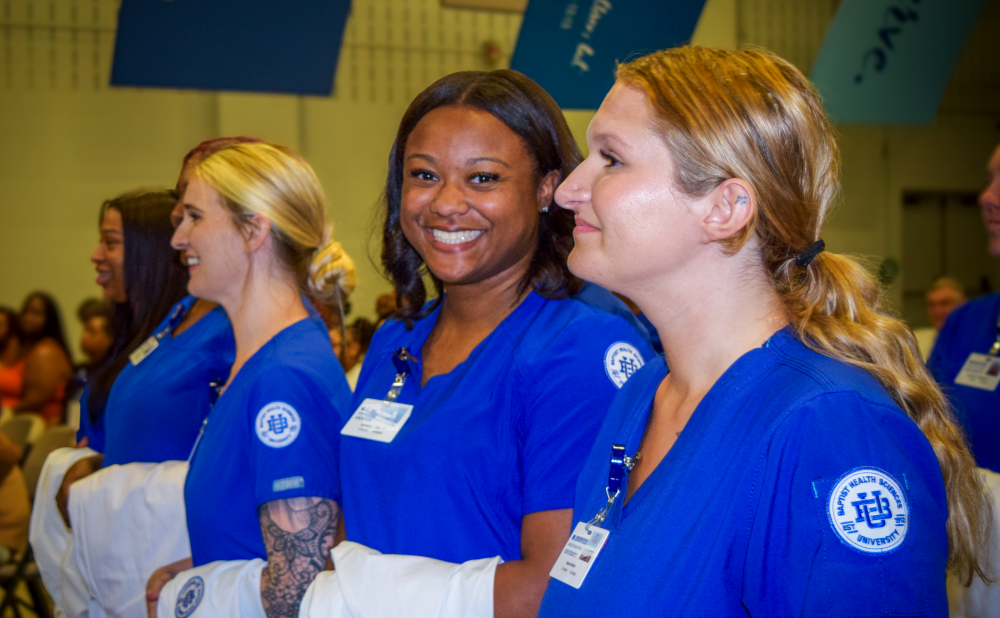 Nursing student looking at the camera smiling at white coat ceremony