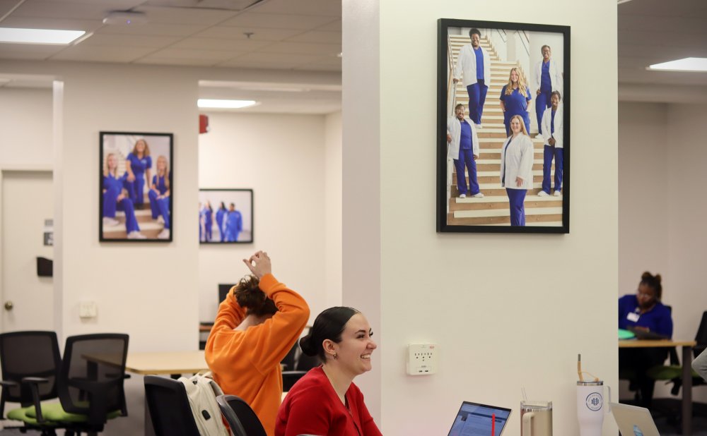 Students gathered at a table with photos on the walls