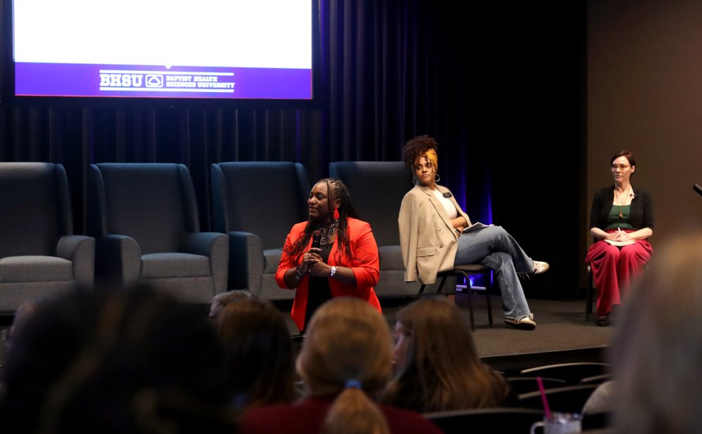 two people on the stage and a speaker on the ground facing the audience