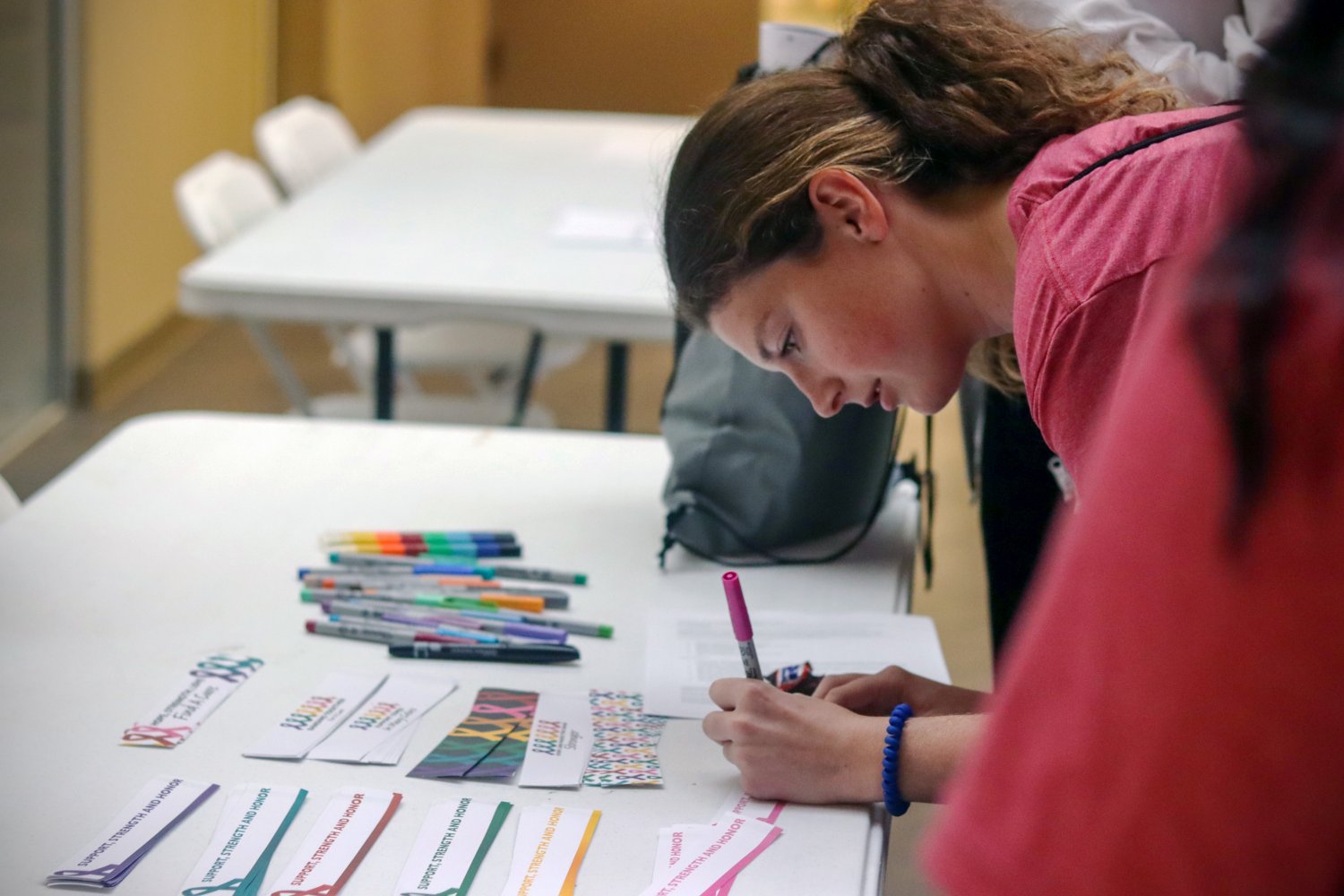 One student writing a pledge card 