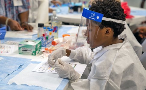 Middle schooler at the HealthCORE Summer Camp with lab gear on 
